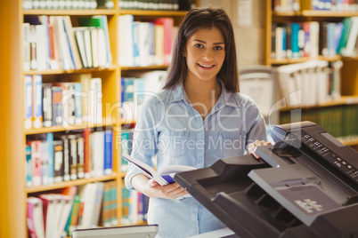 Smiling brunette student making a copy