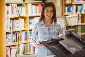 Smiling brunette student making a copy