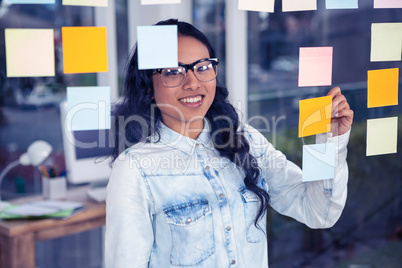 Asian woman writing on sticky notes