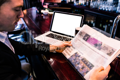 Businessman reading the news and using laptop