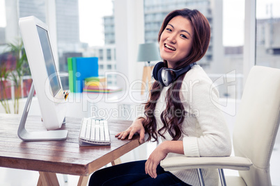 Smiling Asian woman with headphones around neck