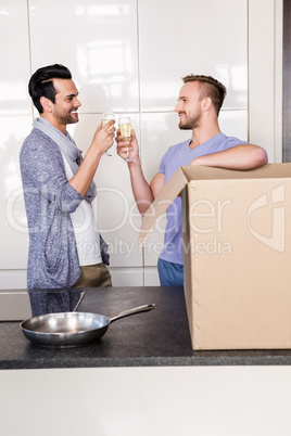 Smiling gay couple toasting with champagne