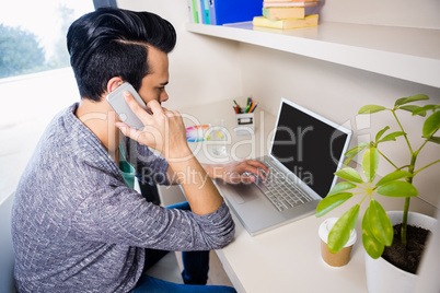 Busy man using smartphone and laptop