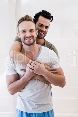 Smiling gay couple hugging
