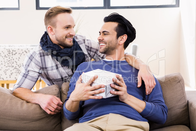 Gay man offering present to his boyfriend