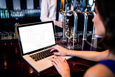 Woman using laptop and having a drink