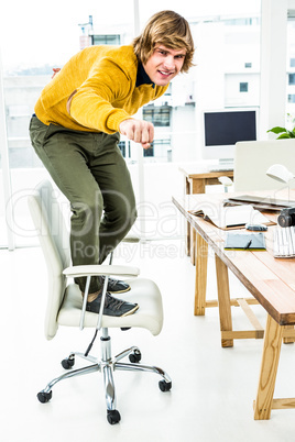 Happy hipster businessman standing on his chair