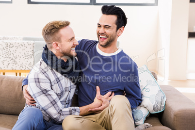Gay couple laughing on the couch
