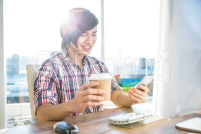 Smiling hipster businessman using smartphone