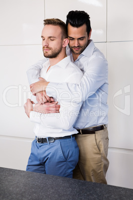 Gay couple with eyes closed hugging