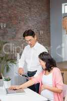 Happy man showing tablet to his pregnant wife