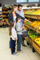 Cute family choosing groceries together