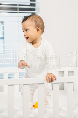 Cute baby standing in the crib