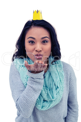 Asian woman with paper crown blowing kiss