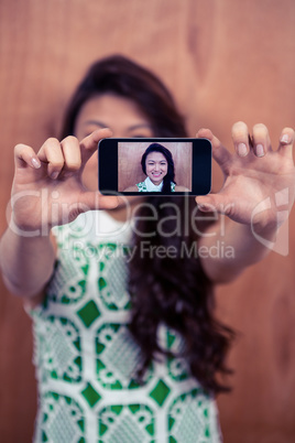 Smiling Asian woman taking selfie