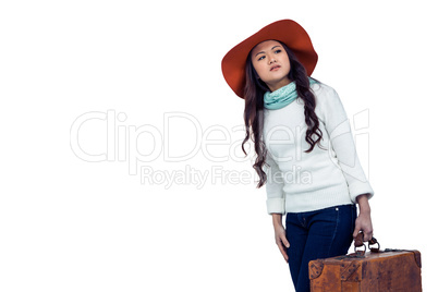 Asian woman with hat holding luggage