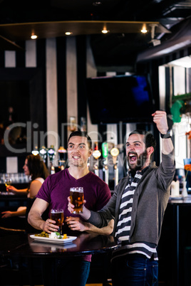 Friends having a pint and watching tv