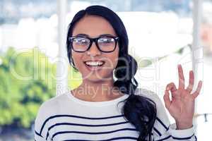 Smiling Asian woman making ok sign with hand