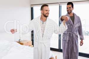 Happy gay couple dancing in bathrobe