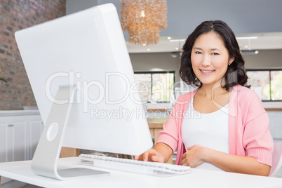 Smiling pregnant woman using computer