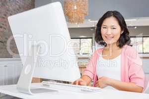 Smiling pregnant woman using computer