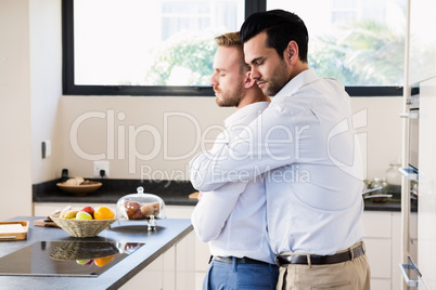 Gay couple with eyes closed hugging