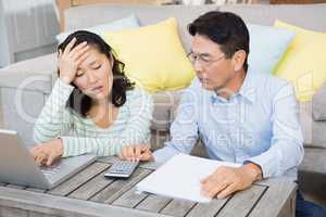 Worried couple checking bills