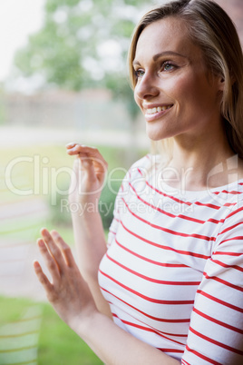 Happy female student looking through the window