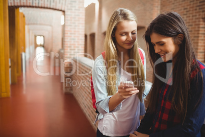 Smiling students using smartphone