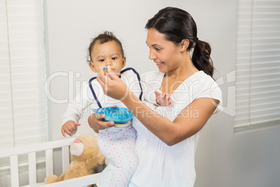 Smiling brunette feeding baby
