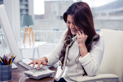 Smiling Asian woman typing telephone number