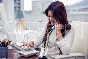 Smiling Asian woman typing telephone number