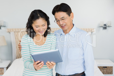 Happy couple using tablet