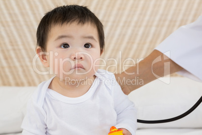 Cute baby being visited by doctor