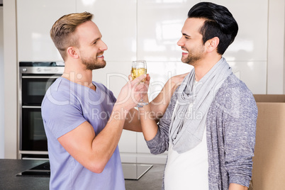 Smiling gay couple toasting with champagne