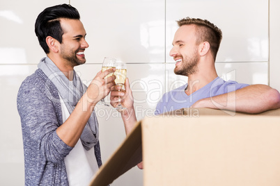 Smiling gay couple toasting with champagne