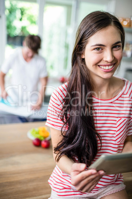 Brunette using tablet in kitchen