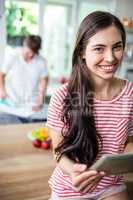 Brunette using tablet in kitchen