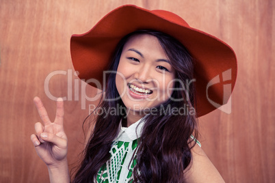 Smiling Asian woman doing peace sign with hand