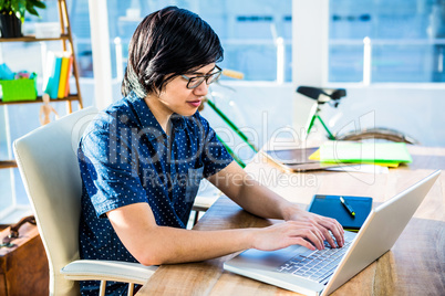 Smiling hipster businessman using laptop