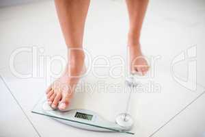 Womans feet going on weighting scale