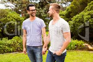 Smiling gay couple walking hand in hand