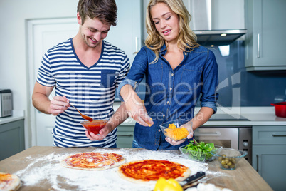 Smiling couple preparing pizza