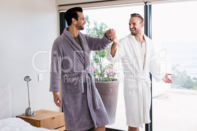 Happy gay couple dancing in bathrobe