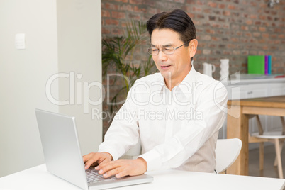 Smiling man using laptop