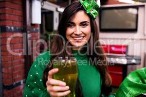 Disguised woman holding a green pint