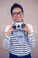 Smiling Asian woman holding camera