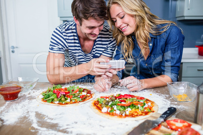 Smiling couple preparing pizza