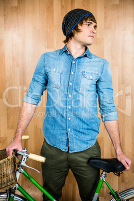 Portrait of hipster standing with bicycle