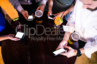 Group of friends texting and having a drink